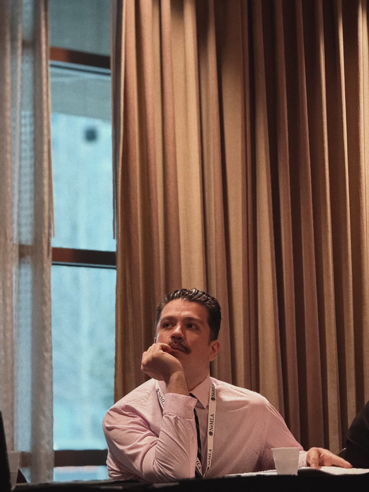 A photo of Anthony Gottlich listening attentively to a paper presentation at a conference.